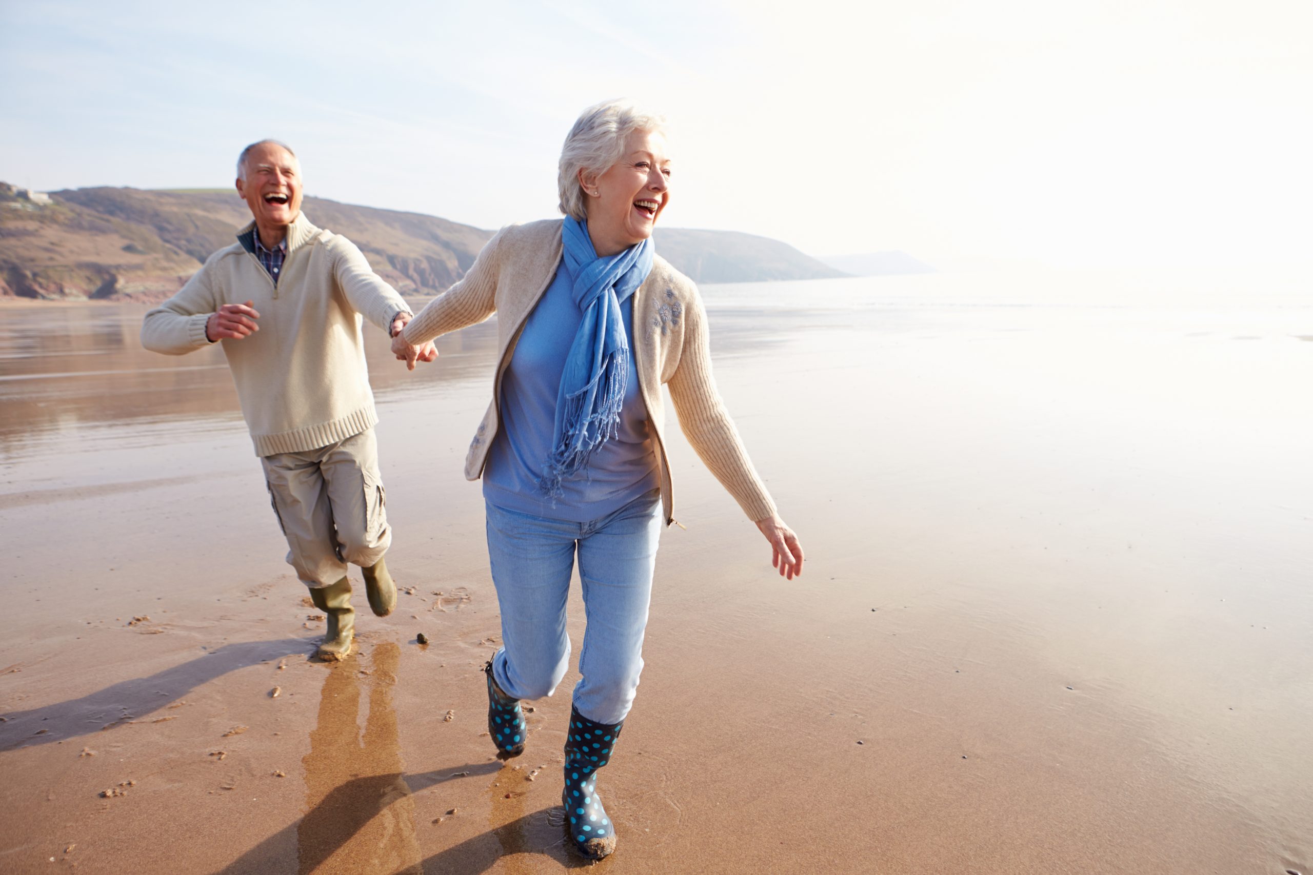 elderly couple walking on beach